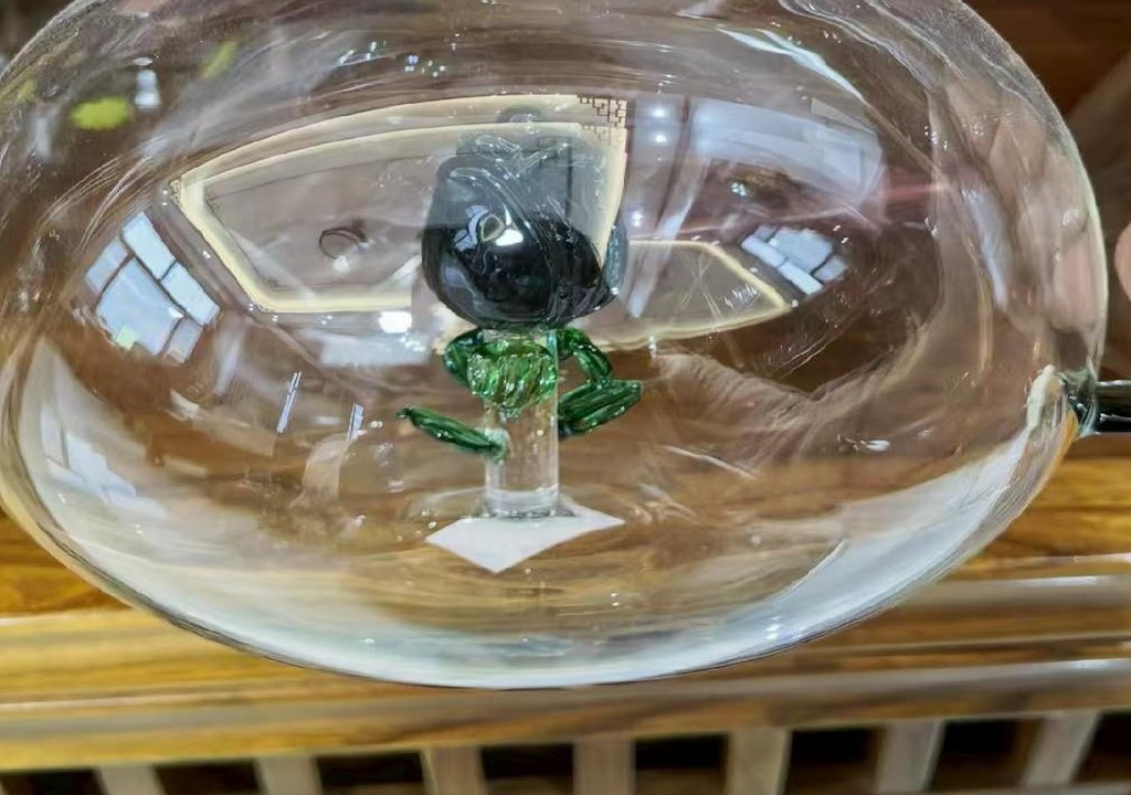 black glass rose figure fused inside a borosilicate glass pitcher