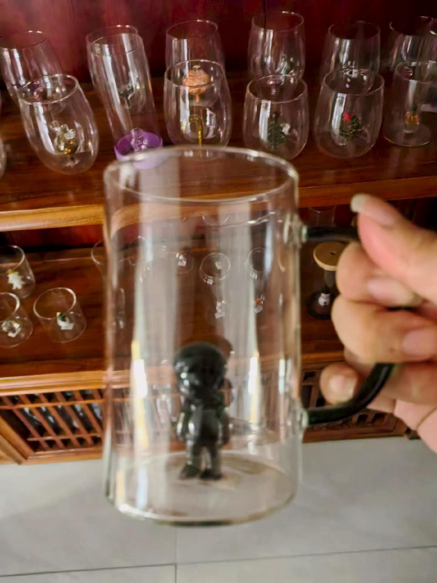 borosilicate glass stein with a 3D figure inside, held by the handle