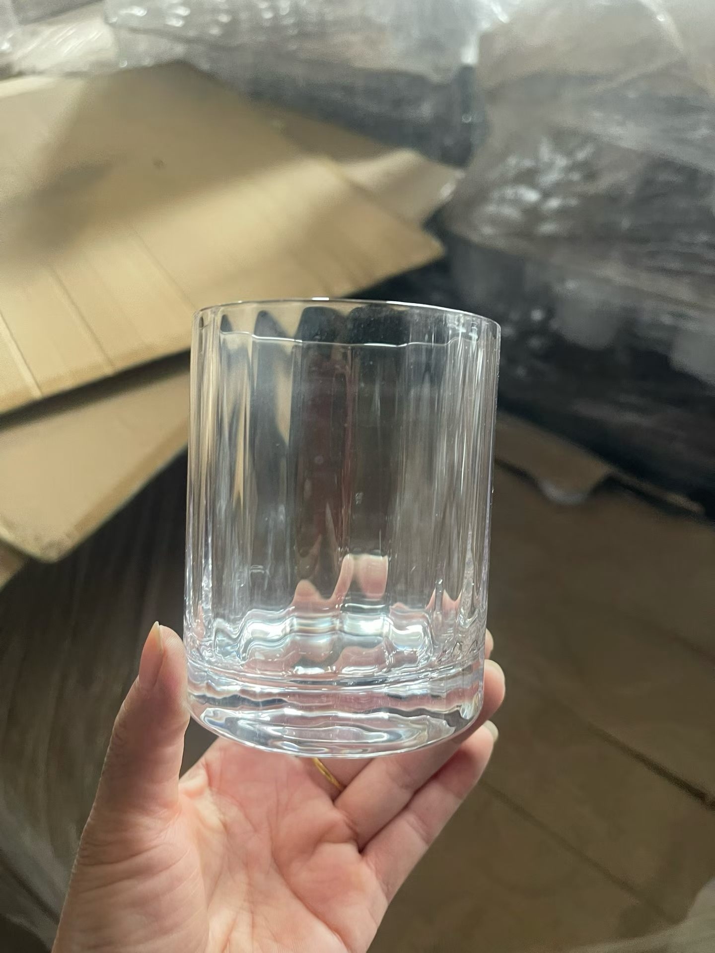 crystal glass ribbed tumbler held up in front of the sample shelf